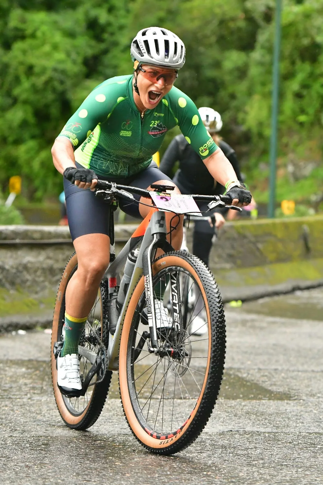 Ciclista de uniforme verde durante uma prova de mountain bike